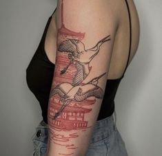 a woman with a tattoo on her arm that has birds flying over the water and pagodas in the background