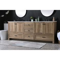 a bathroom vanity with two mirrors above it and a rug on the floor next to it