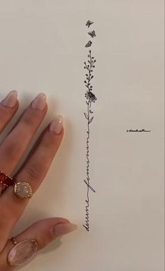 a woman's hand holding a piece of paper with an ink drawing on it