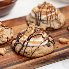 three cookies with marshmallows and chocolate drizzled on the top