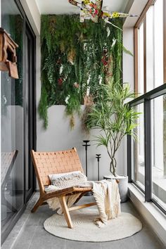 an indoor living area with plants on the wall and a chair in front of it