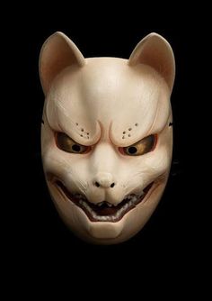 an animal mask with red eyes and fangs on it's face, in the dark