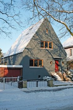 a house is shown with snow on the ground and trees in front of it,