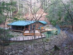 a cabin in the woods with a deck and stairs leading up to it's entrance