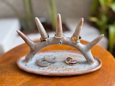 an antler ring holder with two rings on it's side and three other rings in the middle