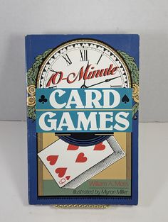 a card game box sitting on top of a white table next to a wall clock