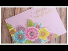 a card with flowers on it sitting on top of a wooden table