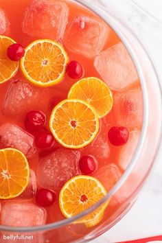 oranges and cranberries are in a bowl with ice