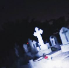 an image of a cemetery at night with the lights on and trees in the background