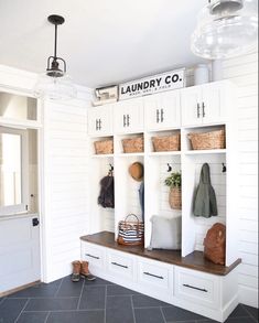 the entryway is clean and organized with baskets, coats, and purses on shelves