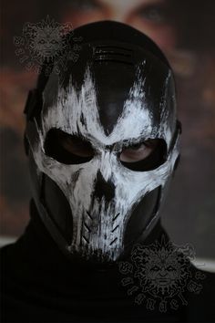 a man with white paint on his face wearing a black and white skull mask,