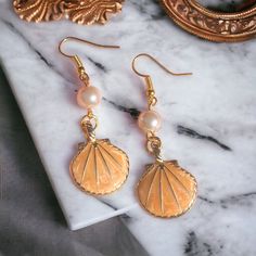 Handmade pale orange pearl and shell earrings. Made in Chichester with loving care. All orders come packed within a lovely Oganza bag. Lovely to wear for any occasion. Statement earrings. Length - 5cm Width - 3cm Made to order and dispatched in one working day. Free standard 2nd class delivery. Upgrade to 1st class for 90p with our express delivery service.  Any questions always feel free to ask, I will respond back very quickly. Thank you ❤️ Shell-shaped Pearl Drop Earrings For Gifts, Shell-shaped Pearl Charm Earrings As Gift, Elegant Gold Shell As Gift, Nickel-free Shell Gift, Shell-shaped Pearl Earrings Gift, Shell-shaped Pearl Earrings For Gift, Pearl Shell-shaped Earrings As Gift, Pearl Shell-shaped Earrings For Gift, Elegant Shell Earrings For Gifts