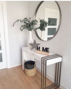 a white table with a mirror and some plants