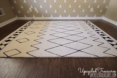 a white rug with black and white designs on it in the corner of a room