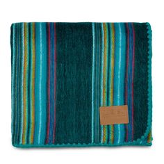 a blue and green striped blanket with a tag on the front, sitting against a white background