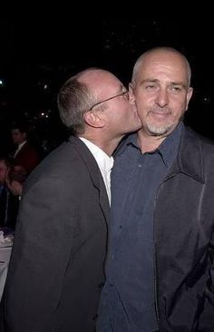 two men kissing each other at an event