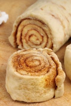 cinnamon rolls on a cutting board next to an apple