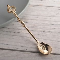 a gold spoon sitting on top of a wooden table