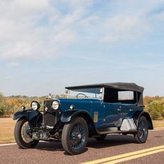 an old car is parked on the side of the road