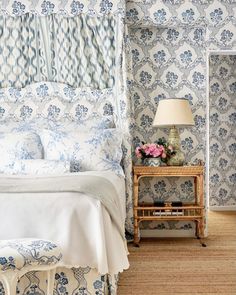 a bedroom with blue and white floral wallpaper