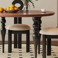 a wooden table with two chairs and a bowl of fruit on top of the table