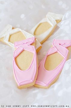 decorated cookies in the shape of ballet shoes on a white tablecloth with polka dots