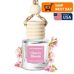 a bottle of cherry bloom perfume next to a flowery branch with the words, car freshener2's cherry blossom on it