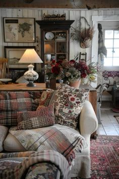 a living room filled with lots of furniture and flowers in vases on the table