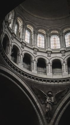 an angel statue is in the middle of a large room with arches and arched windows