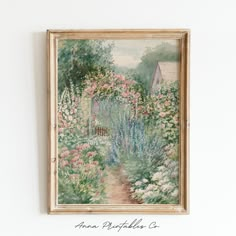 a painting hanging on the wall next to a wooden frame with flowers and a house in the background