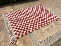 a red and white checkered rug on the ground