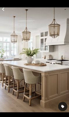 a large kitchen with an island and bar stools