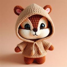 a crocheted teddy bear dressed in a hoodie and sweater with ears on