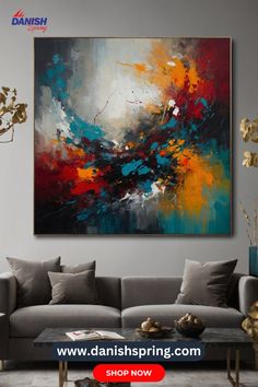 an abstract painting hangs on the wall above a gray couch in a modern living room