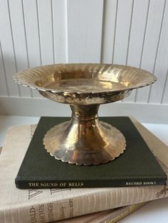 a gold plate sitting on top of a book