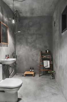 a white toilet sitting in a bathroom next to a sink