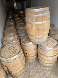 several wooden barrels stacked on top of each other in a room with concrete flooring