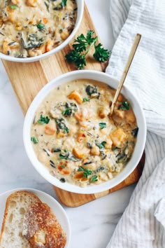 two bowls of soup with bread on the side