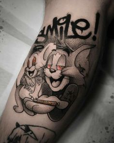 an arm with a cartoon character on it and the word smile written in black ink