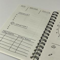 a spiral notebook is open on top of a white table with black lines and numbers