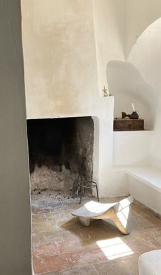 a room with a fire place in the middle and a chair on the floor next to it