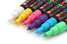 four different colored markers are lined up next to each other