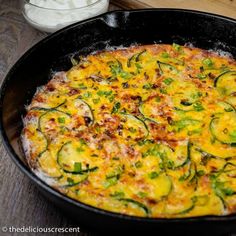 an omelet with zucchini and cheese in a pan on a table