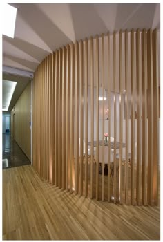 a room with wooden slats on the wall and wood flooring in front of it