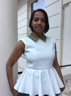 "White peplum blouse with African print collar band and a cap sleeve. It is close fitted with princess seam and an invisible zip at the back.  I made  only 3 pieces in size 12 or medium-sized.  You wear it with a pear of trouser or pencil skirt. A beatiful design. SIZE M  Bust: 36.5\"-37.5\" / 92-94 cm Waist: 28.5\"-30\" / 72-76 cm Hips: 40\"-42\"/ 102-1o7 cm LENGTH: 54cm - 21 inch" Cheap Fitted Blouse With Padded Detail, Cheap Blouse Piece For Traditional Ceremonies, Luxury Fitted Peplum Blouse, Luxury Spring Peplum Blouse, Cheap Unstitched Blouse Piece For Traditional Ceremonies, Cheap Elegant Peplum Top, Cheap Fitted Peplum Blouse, African Print Tops Blouses Peplum, Casual Fitted Blouse With Cute Collar