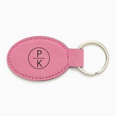 a pink leather keychain with the letter pk on it's side