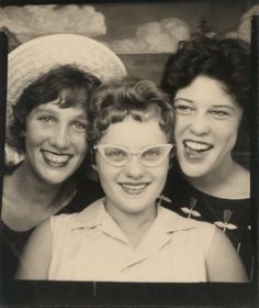 three women are posing for the camera with one woman wearing glasses and the other smiling