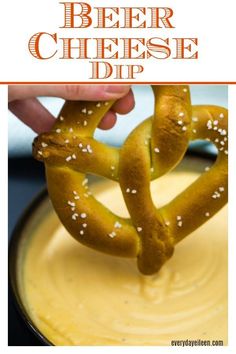 a pretzel being dipped with beer cheese dip