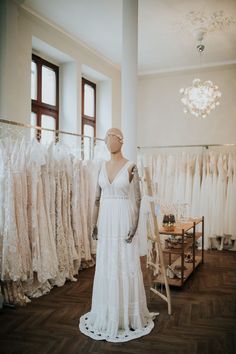 a mannequin is standing in front of wedding gowns