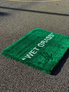 a towel that is laying on the ground with words written on it and a basketball hoop in the background